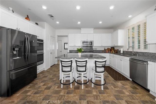 kitchen featuring sink, white cabinets, appliances with stainless steel finishes, and a kitchen island