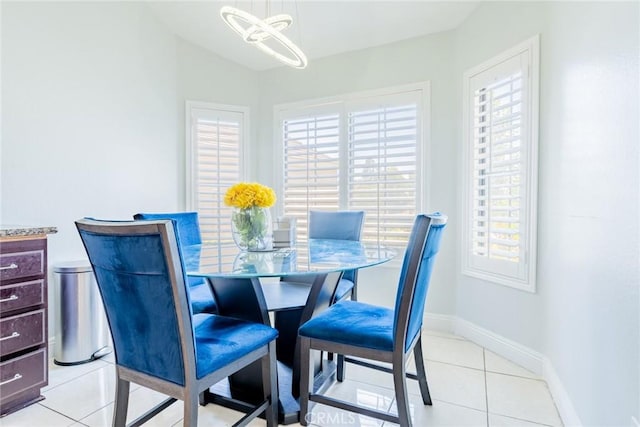 dining area with light tile patterned flooring and an inviting chandelier