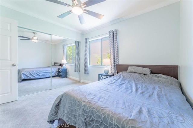 bedroom featuring crown molding, ceiling fan, a closet, and light colored carpet