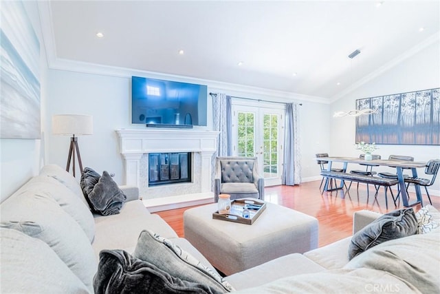 living room featuring a fireplace, hardwood / wood-style floors, ornamental molding, and lofted ceiling