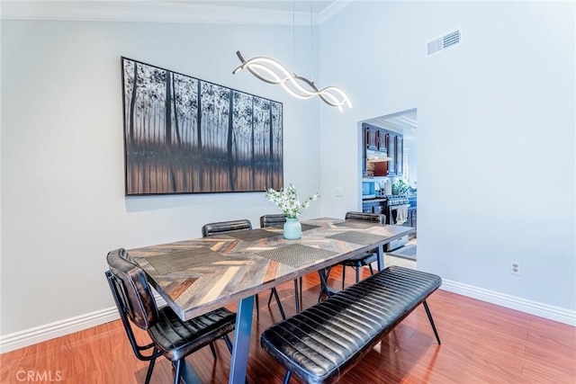 dining room featuring hardwood / wood-style floors and ornamental molding