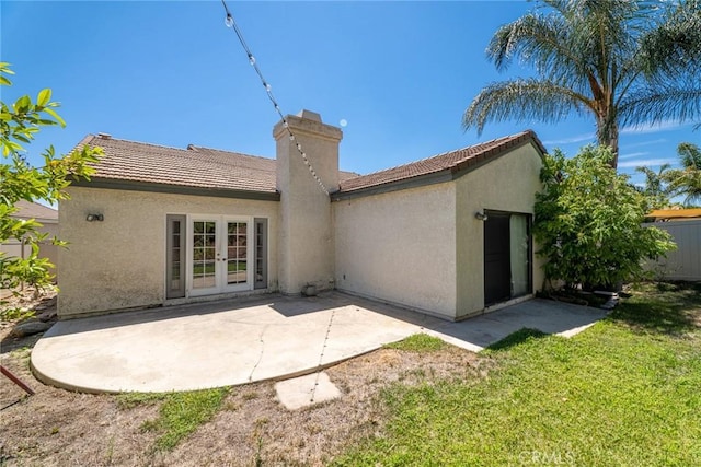 rear view of house with a lawn, a patio area, and french doors