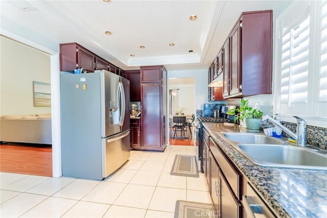 kitchen featuring light tile patterned flooring, a raised ceiling, sink, and appliances with stainless steel finishes