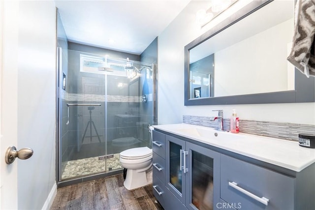 bathroom featuring hardwood / wood-style flooring, vanity, toilet, and walk in shower