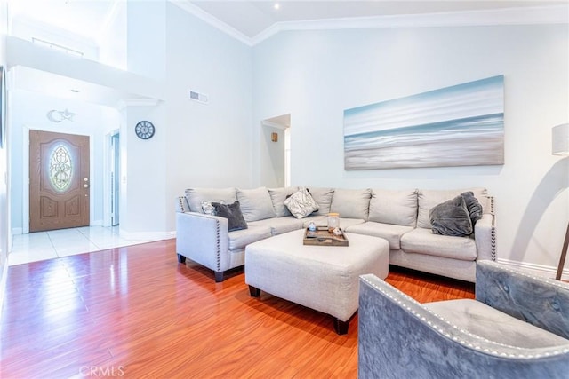 living room featuring crown molding, vaulted ceiling, and hardwood / wood-style flooring