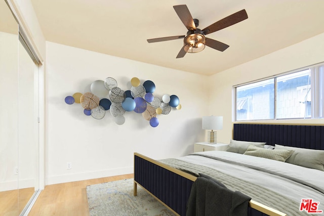 bedroom featuring ceiling fan, a closet, and wood-type flooring