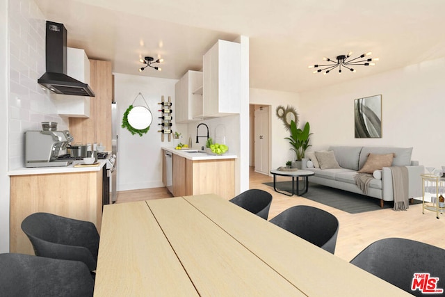 dining space with light hardwood / wood-style flooring, a chandelier, and sink