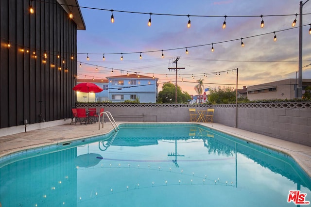 pool at dusk with a patio