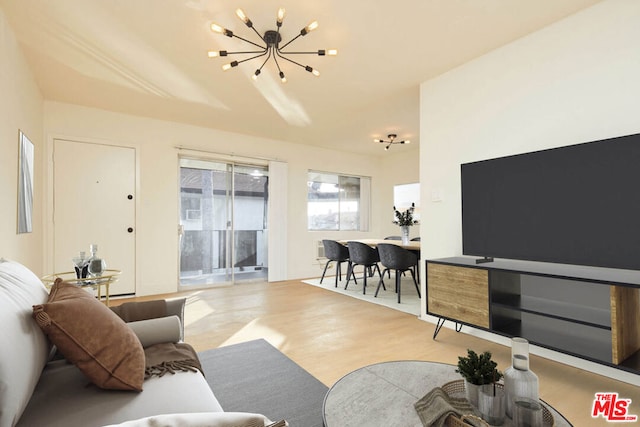 living room with light hardwood / wood-style floors and an inviting chandelier