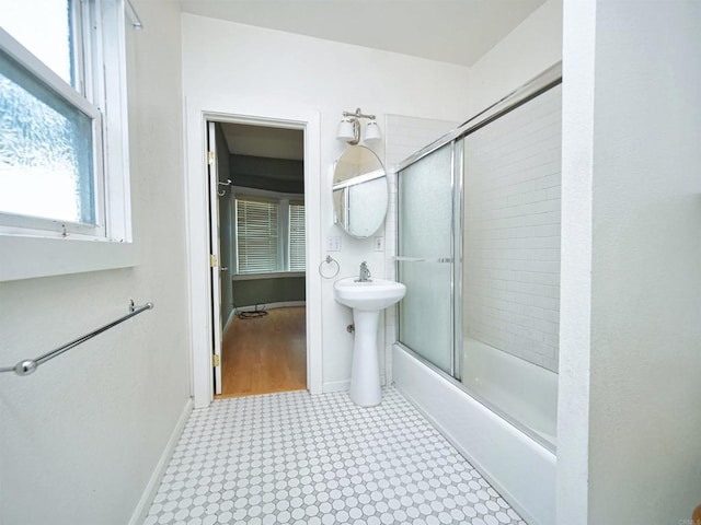 bathroom with bath / shower combo with glass door