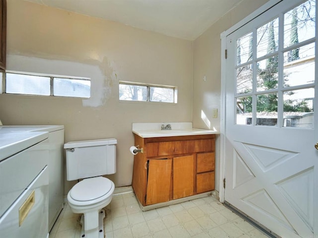 bathroom featuring washer / clothes dryer, vanity, and toilet