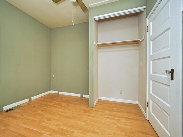 unfurnished bedroom featuring ceiling fan, a closet, and hardwood / wood-style floors