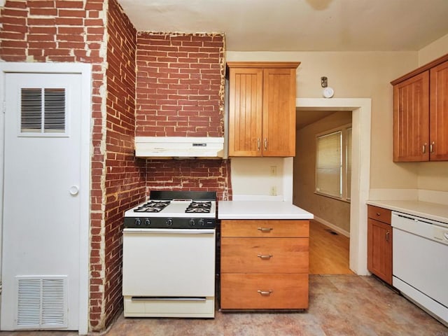 kitchen with white appliances and brick wall