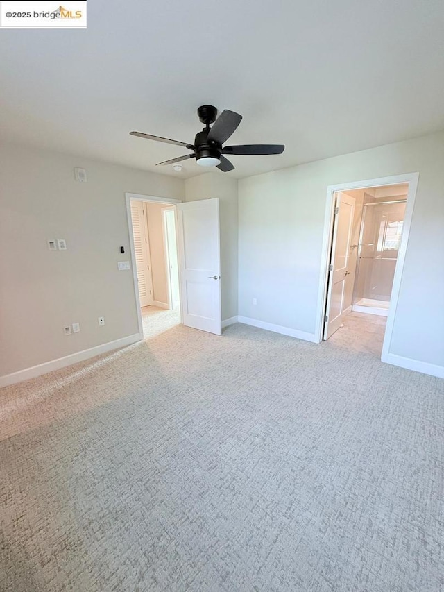 carpeted spare room featuring ceiling fan