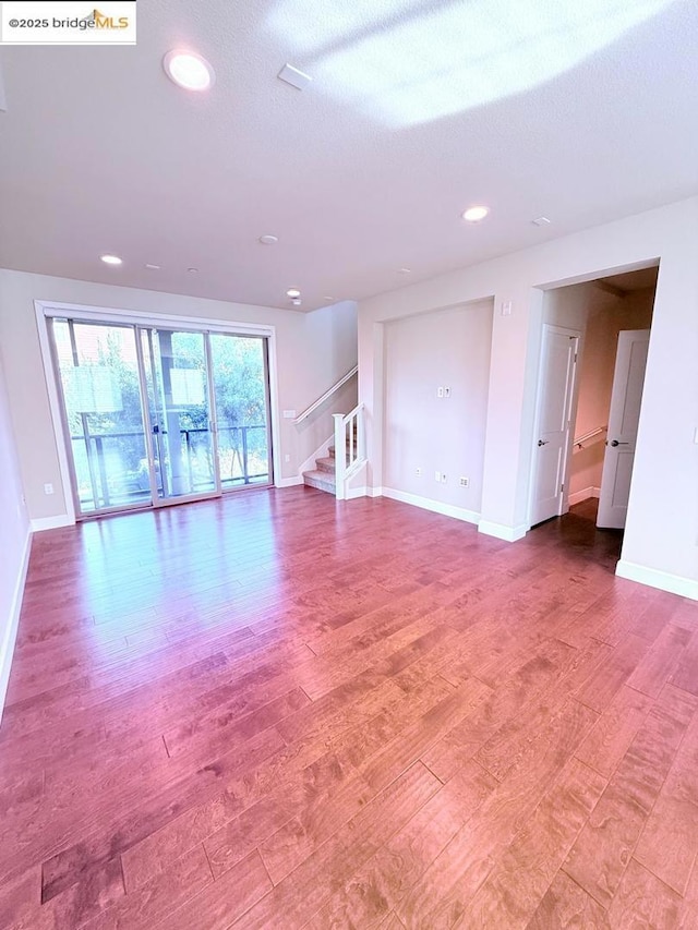 unfurnished living room with wood-type flooring