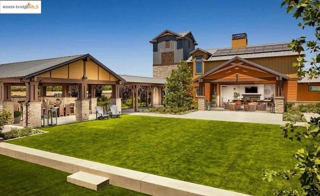 back of property featuring a gazebo, a yard, and exterior kitchen