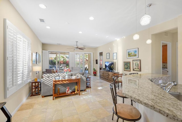 living room featuring ceiling fan and sink