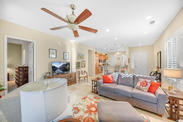 tiled living room with ceiling fan