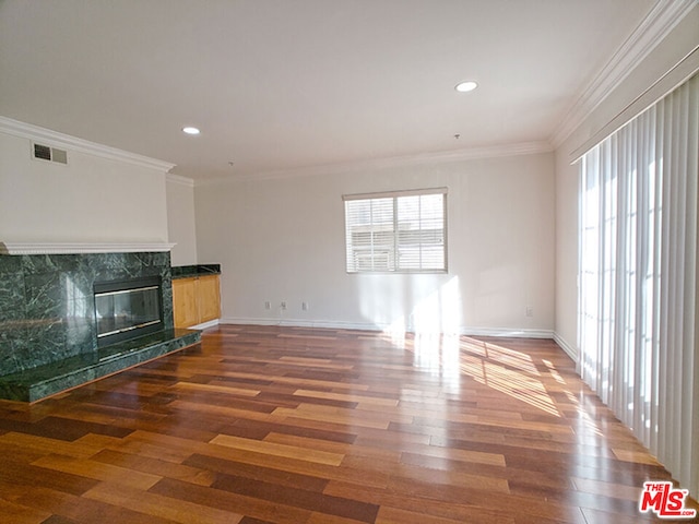 unfurnished living room with a fireplace, crown molding, and dark hardwood / wood-style flooring