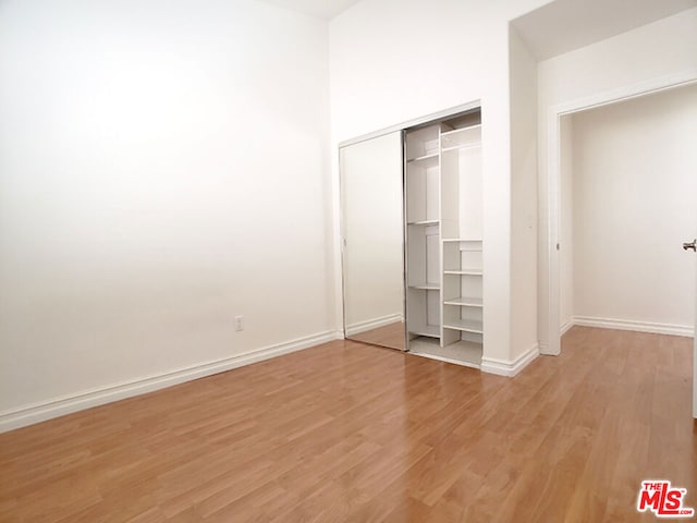 unfurnished bedroom with a closet and light hardwood / wood-style flooring