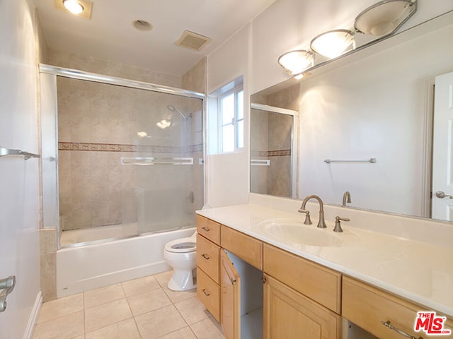 full bathroom featuring tile patterned floors, vanity, toilet, and enclosed tub / shower combo