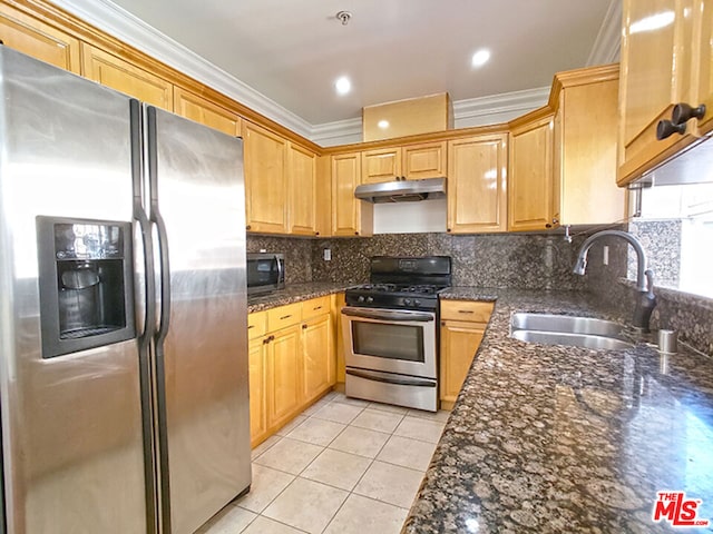 kitchen featuring dark stone countertops, stainless steel appliances, ornamental molding, and sink