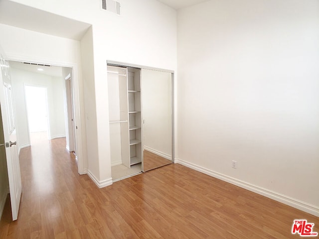 unfurnished bedroom featuring light wood-type flooring and a closet