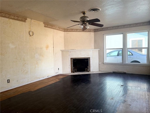 unfurnished living room featuring ceiling fan, wood-type flooring, and a textured ceiling