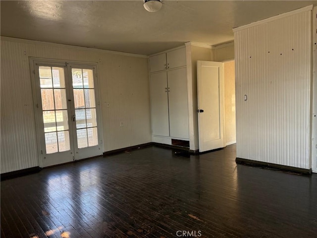 unfurnished room with dark wood-type flooring, ornamental molding, and french doors