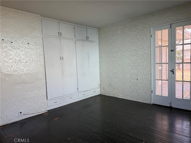 unfurnished bedroom featuring french doors, dark hardwood / wood-style floors, and a closet