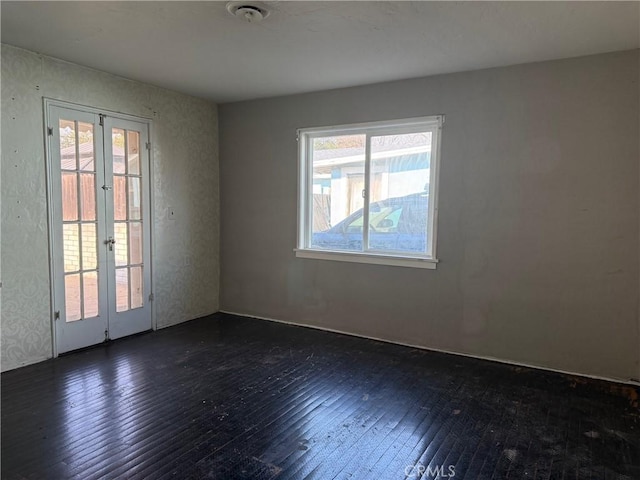 spare room featuring french doors and dark hardwood / wood-style floors