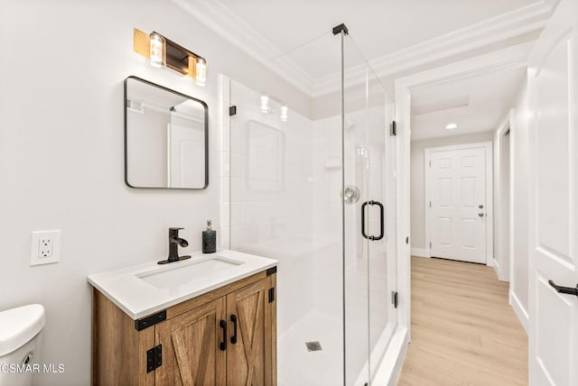 bathroom featuring an enclosed shower, vanity, wood-type flooring, ornamental molding, and toilet