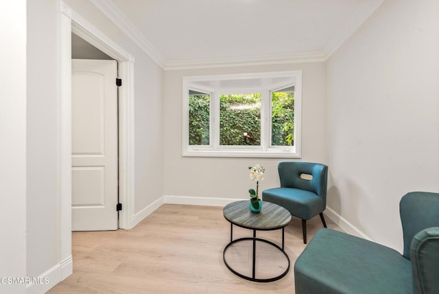 living area featuring crown molding and light hardwood / wood-style flooring