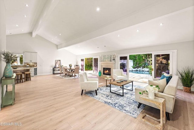 living room featuring high vaulted ceiling, light hardwood / wood-style floors, and beamed ceiling