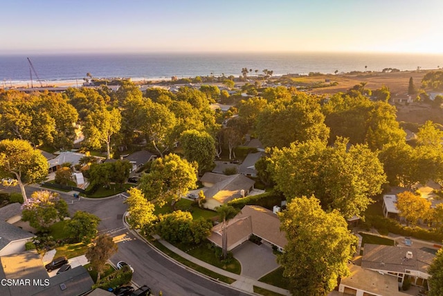 aerial view at dusk featuring a water view