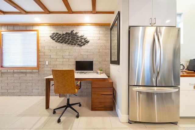 tiled home office with beamed ceiling and brick wall