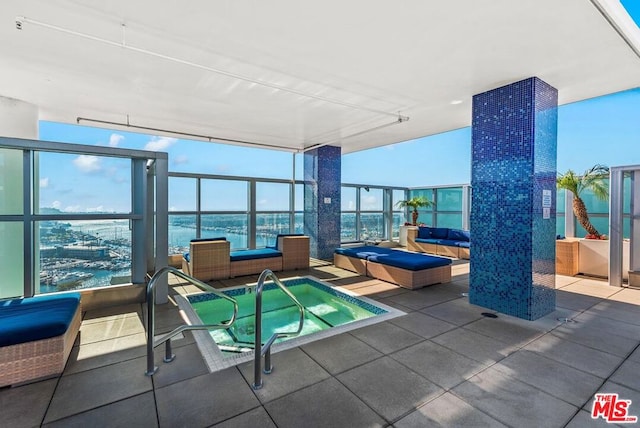 view of swimming pool featuring a water view and an indoor in ground hot tub