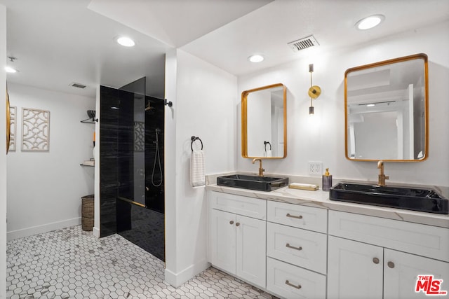 bathroom with tile patterned floors, vanity, and a tile shower