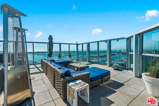 view of patio / terrace with a water view and an outdoor living space with a fire pit