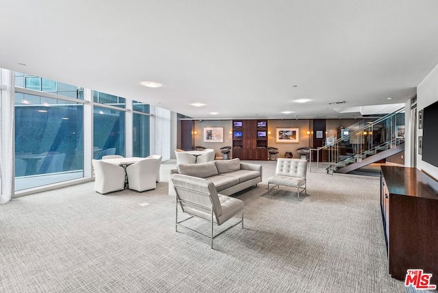 carpeted living room featuring a wall of windows