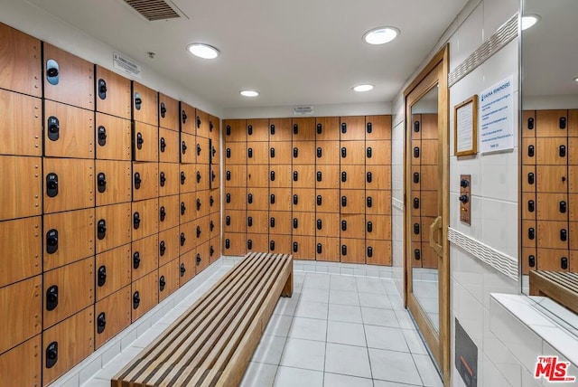 wine cellar featuring light tile patterned flooring, tile walls, and mail boxes