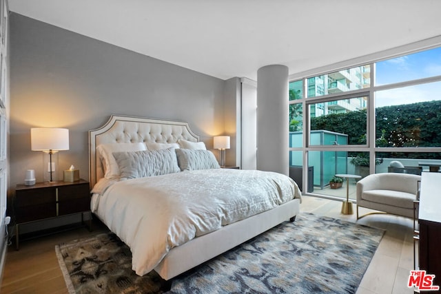 bedroom featuring dark hardwood / wood-style flooring and expansive windows