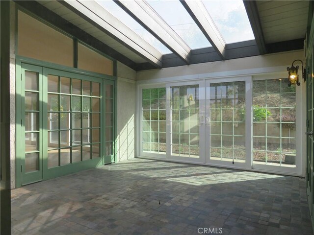 unfurnished sunroom with vaulted ceiling with skylight