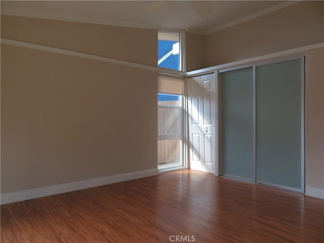 unfurnished bedroom featuring ornamental molding, ceiling fan, hardwood / wood-style flooring, a closet, and lofted ceiling