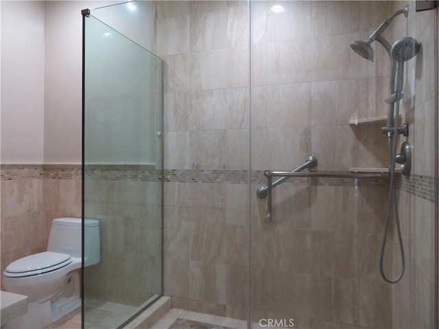 bathroom featuring walk in shower, tile walls, and toilet