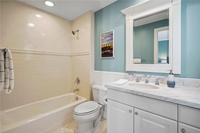 full bathroom featuring wainscoting, toilet, shower / tub combination, tile patterned flooring, and vanity