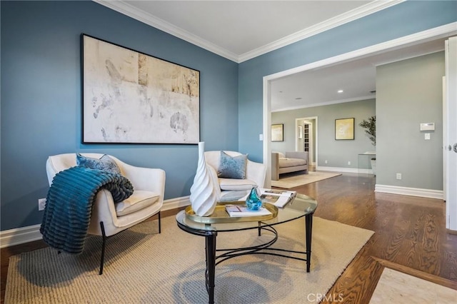 sitting room featuring baseboards, crown molding, and wood finished floors