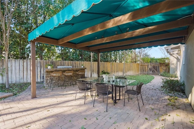 view of patio / terrace with outdoor dining area, a fenced backyard, and outdoor dry bar