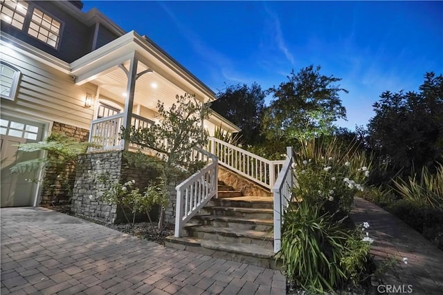 view of home's exterior with stone siding and stairway