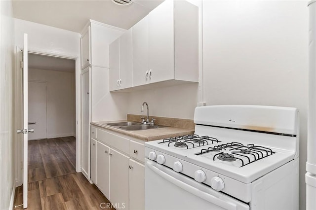 kitchen with dark hardwood / wood-style floors, sink, white cabinetry, and white gas range oven